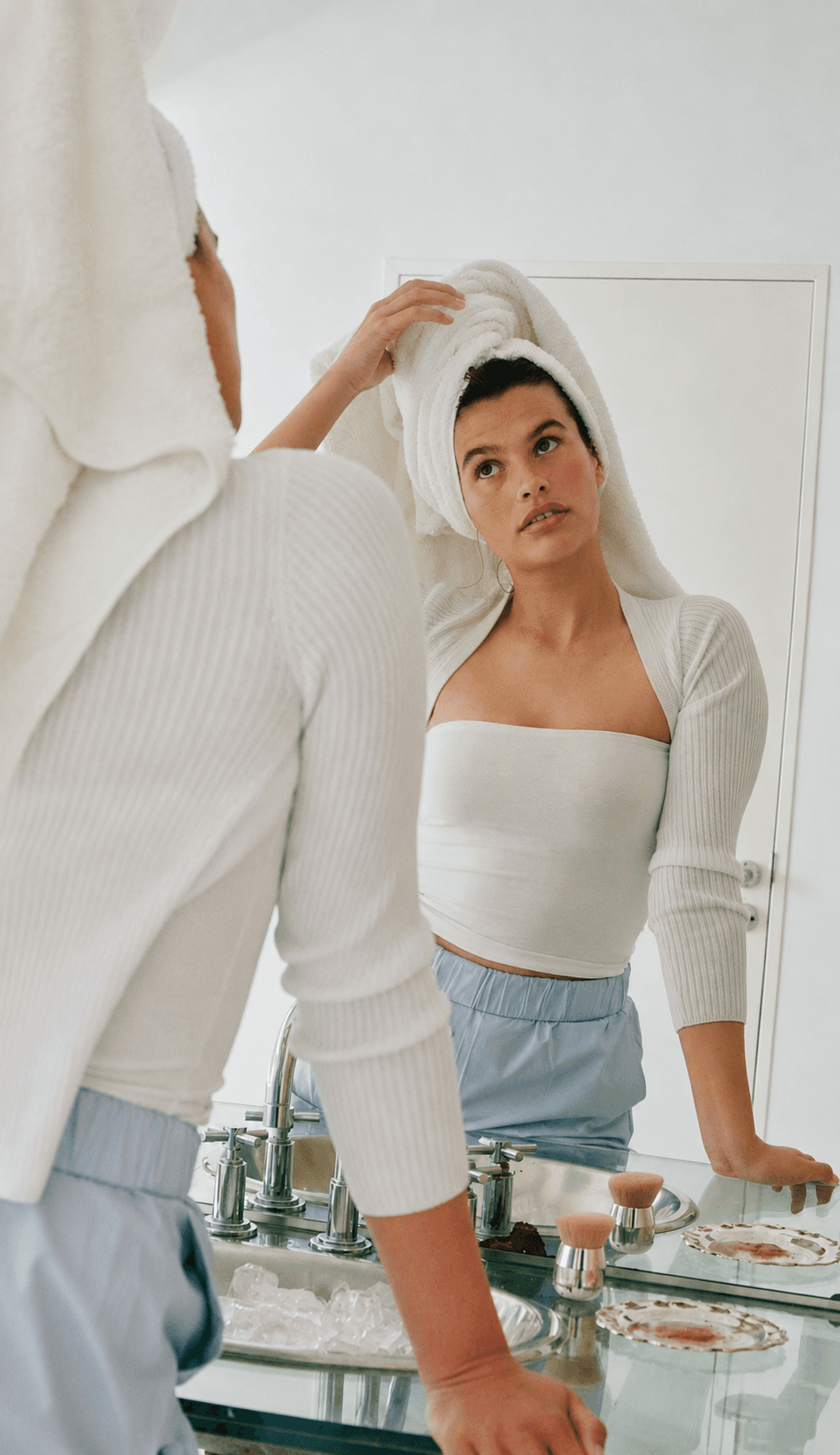 Woman looking in a bathroom mirror